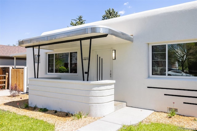 view of front facade featuring fence and stucco siding