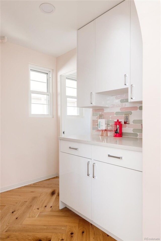 1010 N Jasmine St, Denver, CO 80220 - kitchen with white cabinetry, light countertops, and decorative backsplash