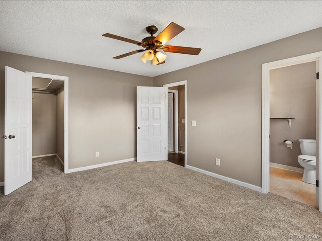1642 S Salida Way, Aurora, CO 80017 - unfurnished bedroom featuring carpet flooring, a walk in closet, connected bathroom, baseboards, and a textured ceiling
