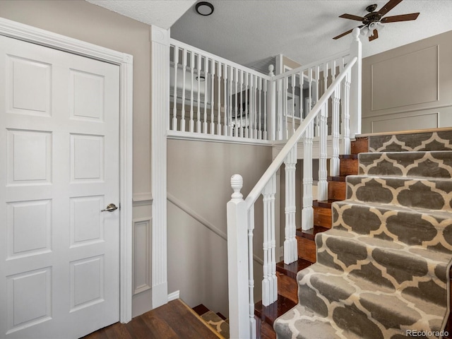 1642 S Salida Way, Aurora, CO 80017 - stairs with wood finished floors, a ceiling fan, a decorative wall, and a textured ceiling