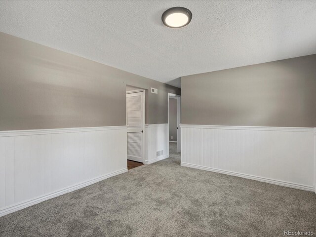 1642 S Salida Way, Aurora, CO 80017 - carpeted empty room featuring a wainscoted wall and a textured ceiling