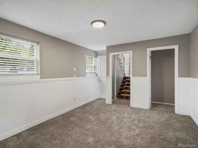 1642 S Salida Way, Aurora, CO 80017 - unfurnished bedroom featuring a wainscoted wall, carpet flooring, and a textured ceiling