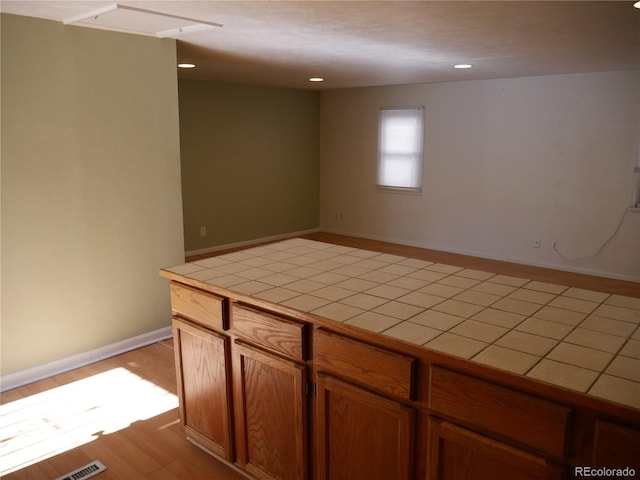 kitchen with tile counters and light wood-type flooring