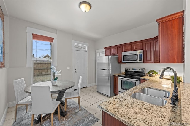 kitchen featuring stainless steel appliances, sink, light tile patterned floors, and light stone counters