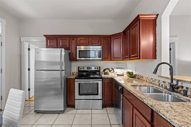 kitchen featuring light stone counters, sink, stainless steel appliances, and light tile patterned flooring