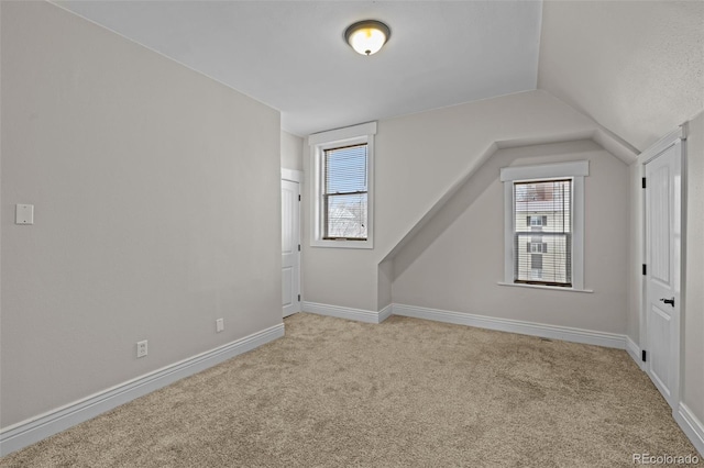 bonus room with light carpet and lofted ceiling