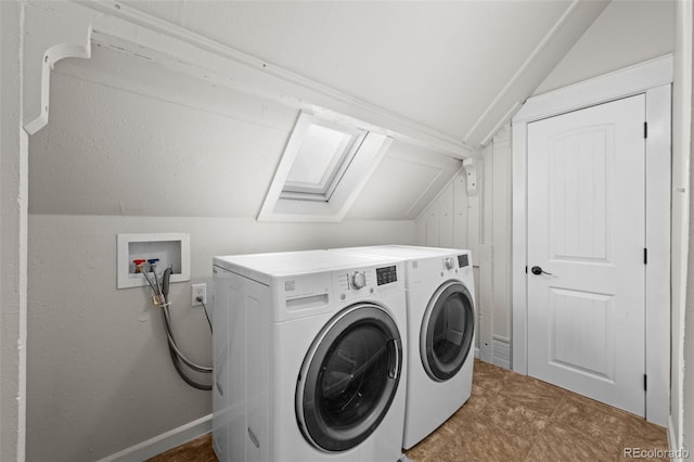 clothes washing area featuring washing machine and clothes dryer and a skylight