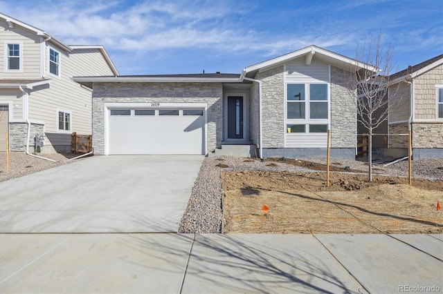 view of front of house featuring stone siding, an attached garage, and driveway