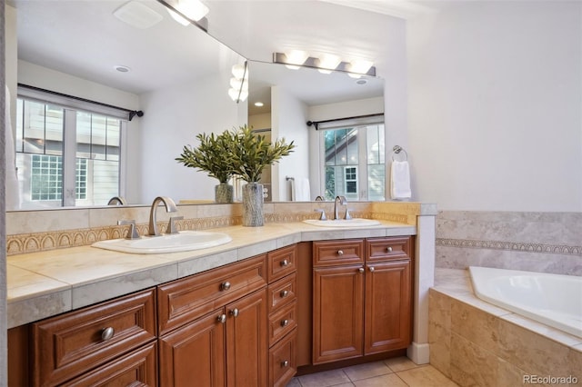 bathroom with tile patterned flooring, vanity, and a relaxing tiled tub