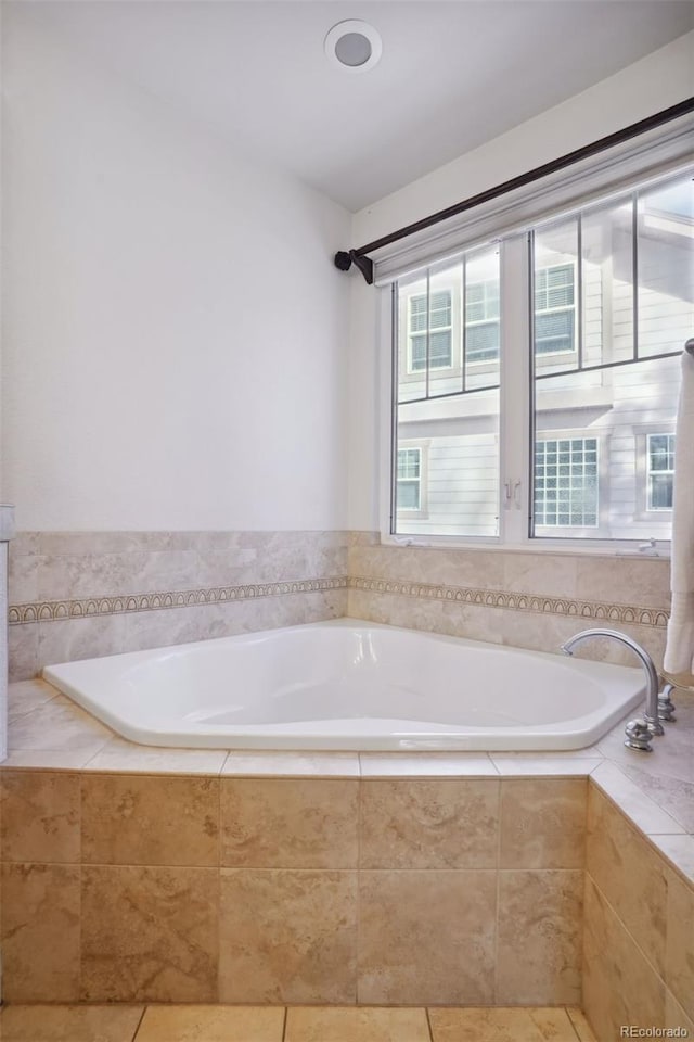 bathroom featuring tile patterned floors and tiled bath