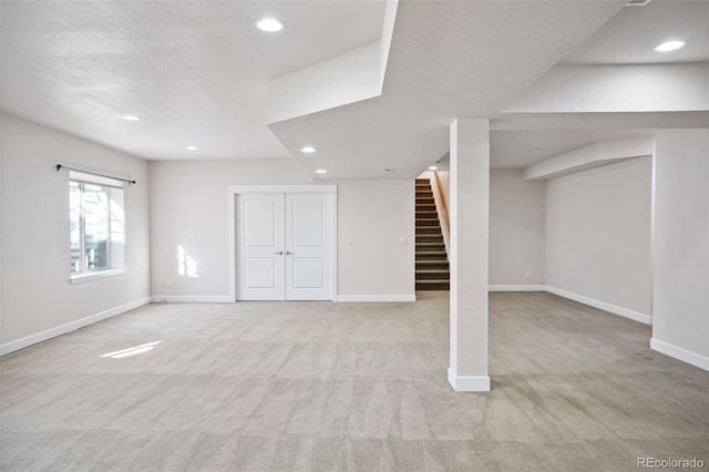 basement with light colored carpet and a textured ceiling