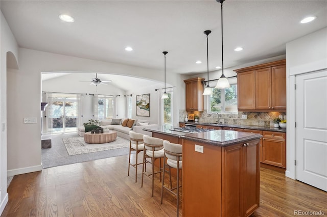 kitchen featuring a center island, decorative light fixtures, ceiling fan, and dark hardwood / wood-style floors