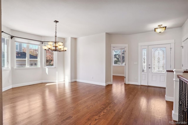 foyer entrance featuring an inviting chandelier and dark wood-type flooring