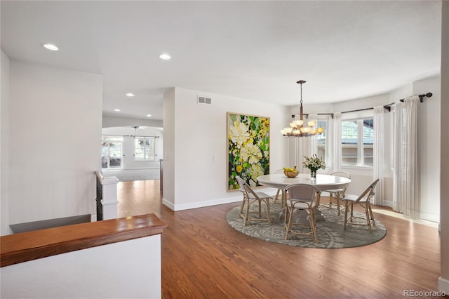 dining area featuring dark hardwood / wood-style floors, a wealth of natural light, and a notable chandelier