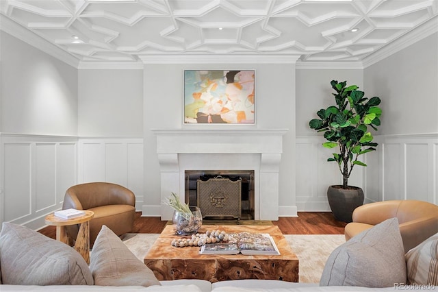 living room featuring coffered ceiling, light hardwood / wood-style floors, and ornamental molding