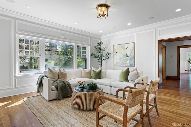 living room featuring light hardwood / wood-style flooring and ornamental molding