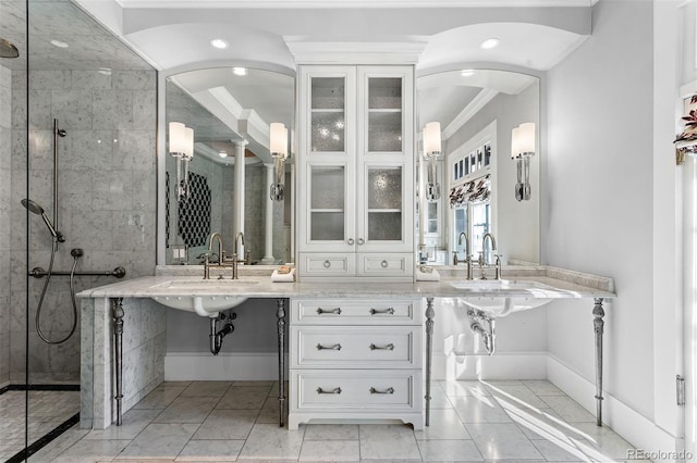 bathroom with sink, ornamental molding, and tiled shower