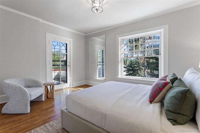 bedroom featuring access to outside, ornamental molding, and hardwood / wood-style floors