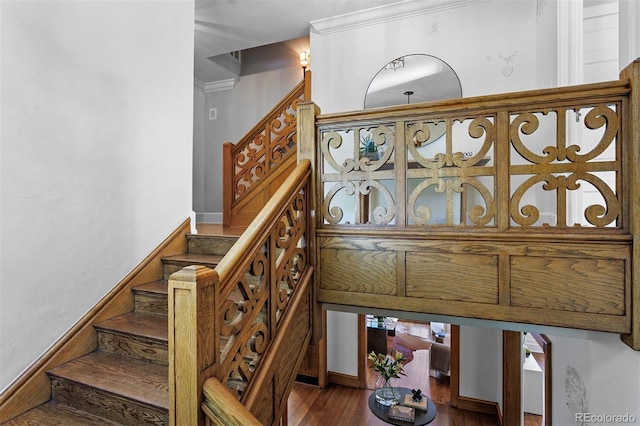 stairs featuring hardwood / wood-style flooring and crown molding