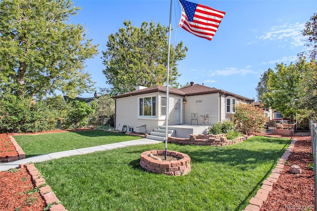 view of front of house featuring a patio, a front lawn, an outdoor fire pit, and fence