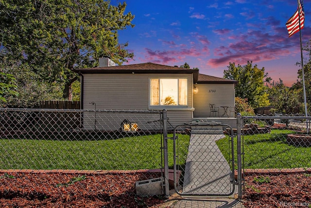 bungalow-style home featuring a gate, a lawn, and fence