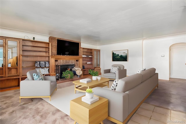 living room with a brick fireplace and arched walkways