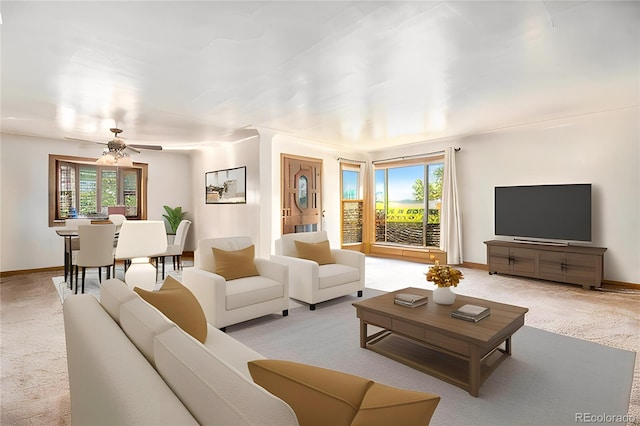 living area with carpet flooring, baseboards, and ceiling fan