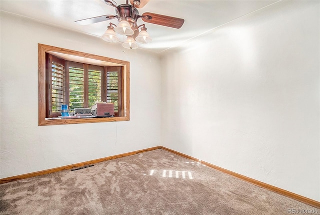 carpeted spare room featuring ceiling fan, baseboards, and visible vents