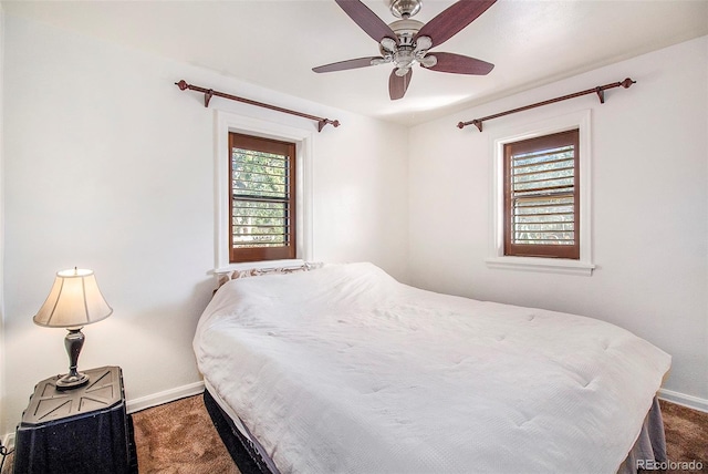 bedroom with dark colored carpet, baseboards, and multiple windows