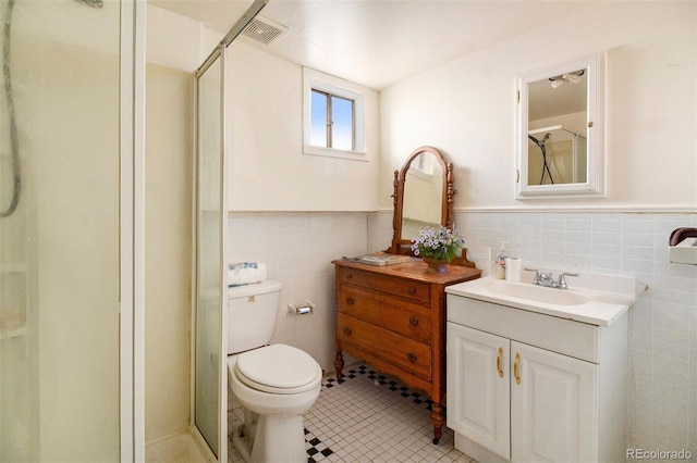 bathroom featuring tile walls, visible vents, tile patterned flooring, and a stall shower