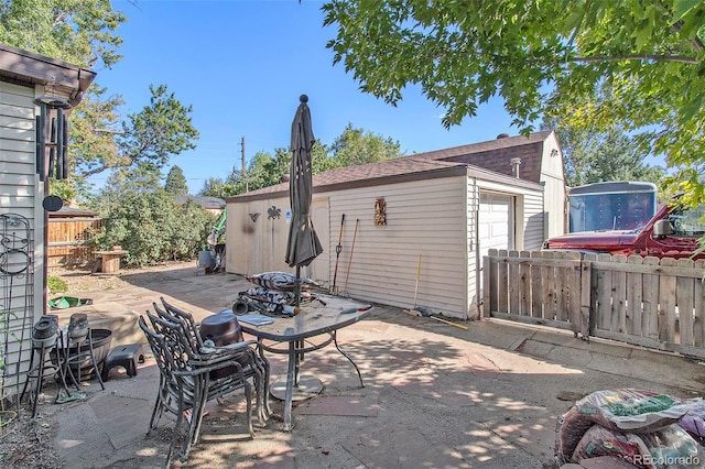 view of patio with an outbuilding and fence