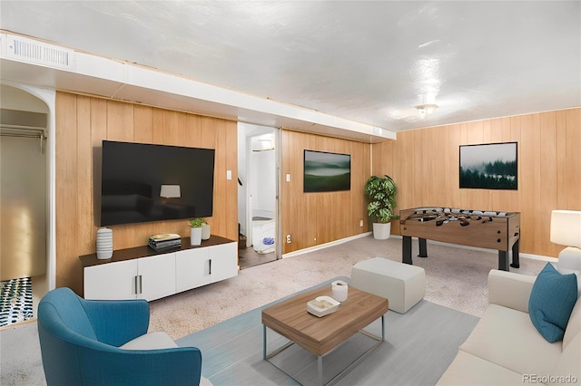 carpeted living area featuring wood walls and visible vents