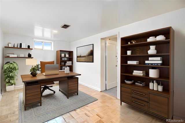 office space with baseboards and visible vents