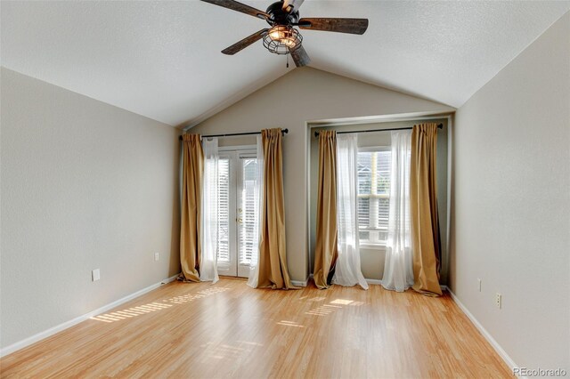 empty room featuring lofted ceiling, ceiling fan, light wood-type flooring, and baseboards