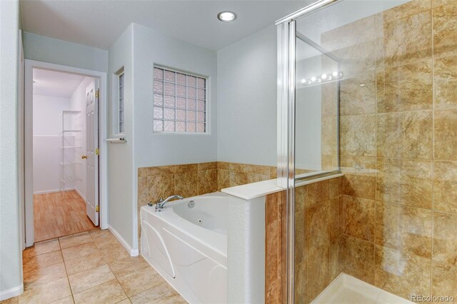 full bath with baseboards, a jetted tub, a shower stall, and tile patterned floors