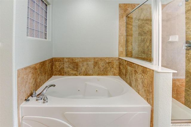 bathroom featuring a whirlpool tub and tiled shower