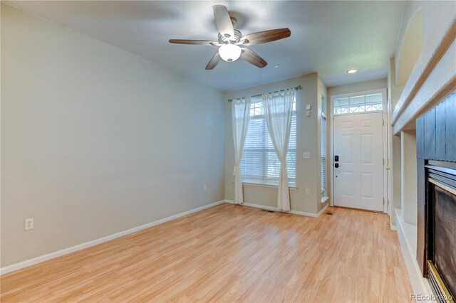 entrance foyer featuring plenty of natural light, ceiling fan, light wood-type flooring, and baseboards