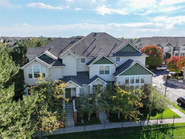 view of front facade featuring a residential view, fence, and stairs