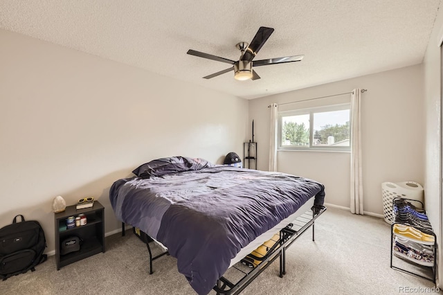 carpeted bedroom with a textured ceiling, baseboards, and ceiling fan