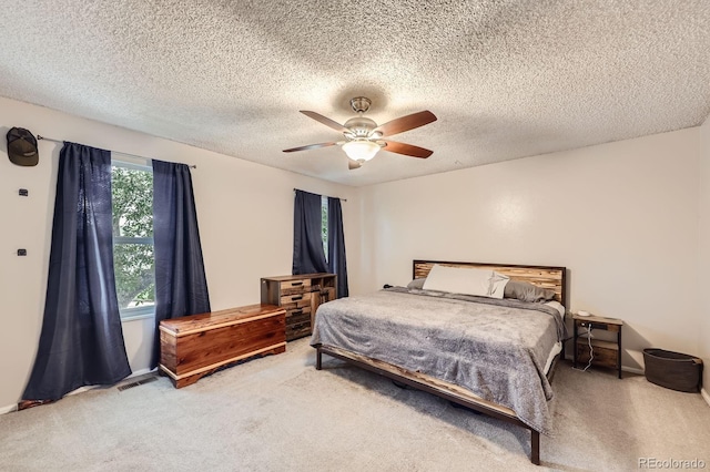 bedroom with visible vents, carpet floors, a textured ceiling, and ceiling fan