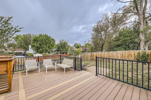 wooden deck with a fenced backyard