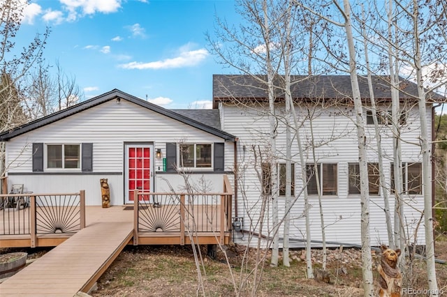 view of front of property featuring roof with shingles and a deck