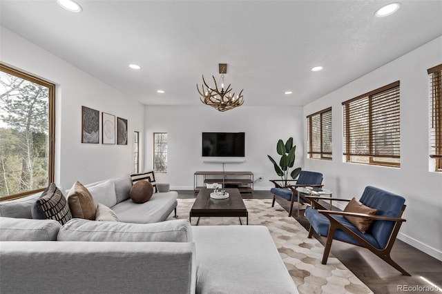 living area with recessed lighting, a chandelier, light wood-style floors, and baseboards