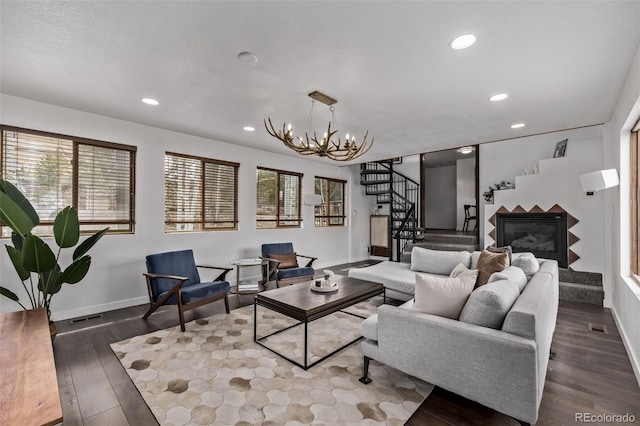 living room with wood finished floors, baseboards, a chandelier, and stairway