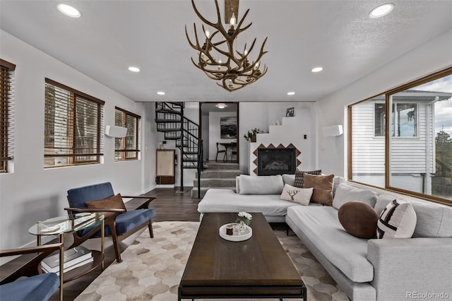 living area with stairway, wood finished floors, an inviting chandelier, baseboards, and recessed lighting