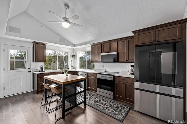 kitchen featuring dark brown cabinets, stainless steel appliances, a ceiling fan, and light countertops
