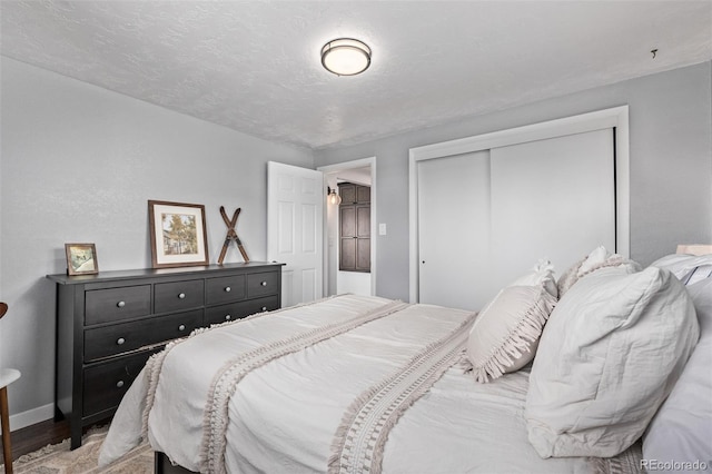 bedroom with a closet, light wood finished floors, and baseboards