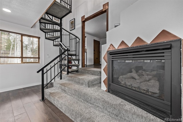 staircase with baseboards and wood finished floors