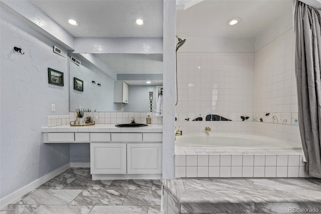 bathroom featuring a bath, vanity, marble finish floor, baseboards, and recessed lighting