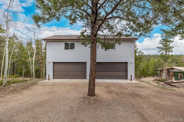 garage with dirt driveway